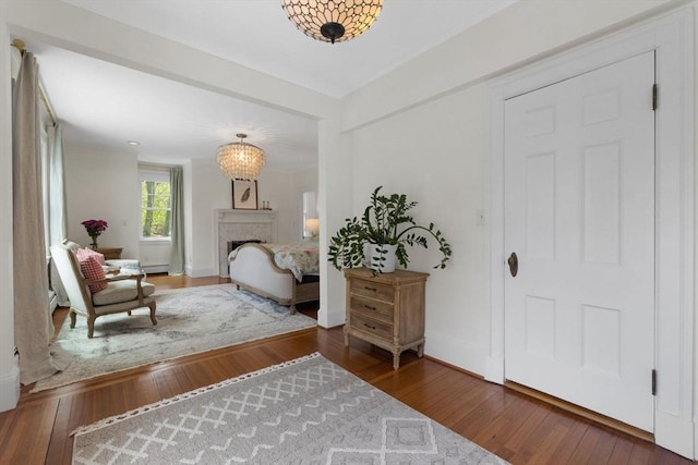entrance foyer with hardwood / wood-style floors, baseboards, and a fireplace