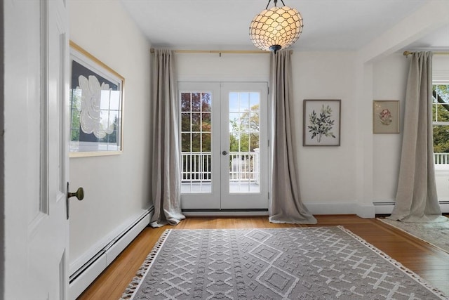 doorway with a baseboard heating unit, french doors, and light wood-style floors