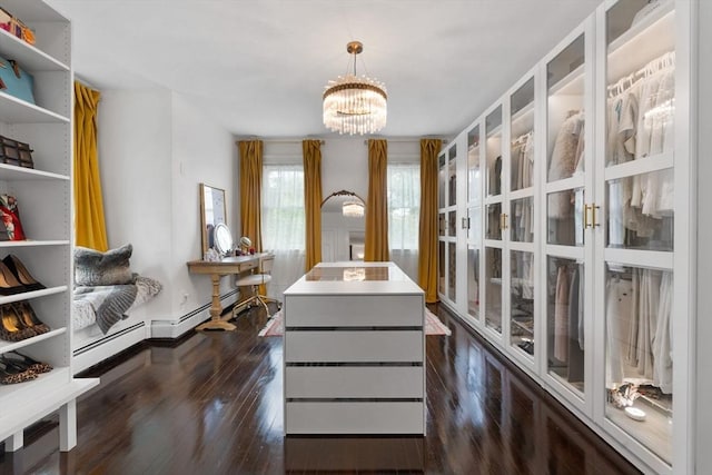 walk in closet featuring a chandelier and dark wood finished floors