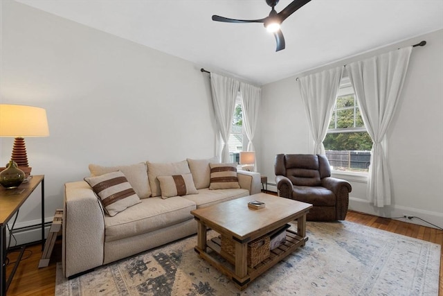 living room with ceiling fan, wood finished floors, baseboards, and baseboard heating