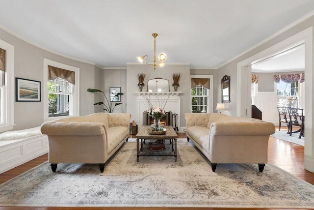 living area with a chandelier, wood finished floors, and crown molding