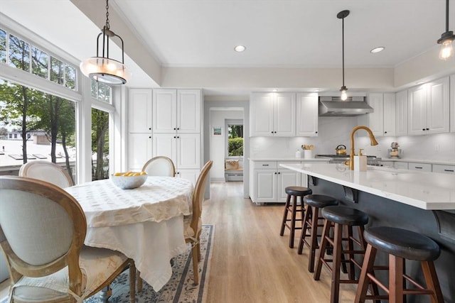 dining area featuring light wood finished floors, crown molding, recessed lighting, and baseboard heating