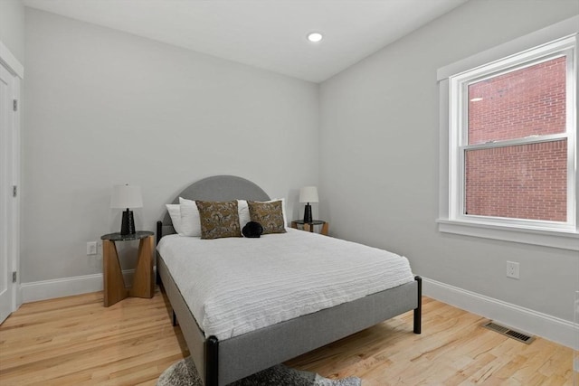 bedroom with recessed lighting, wood finished floors, visible vents, and baseboards