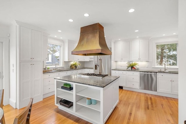 kitchen with open shelves, stainless steel appliances, white cabinets, and island range hood