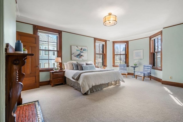 carpeted bedroom featuring crown molding and baseboards