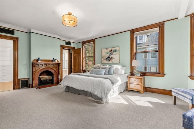 carpeted bedroom featuring crown molding, a brick fireplace, baseboards, and visible vents