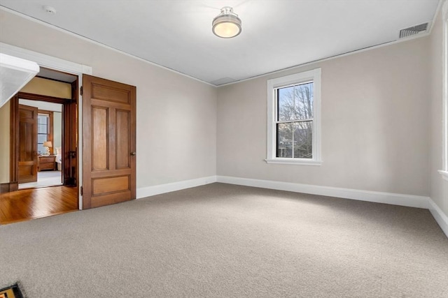 spare room with visible vents, baseboards, and carpet floors