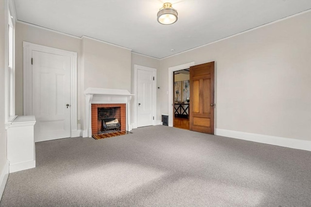 unfurnished living room with ornamental molding, baseboards, and carpet floors