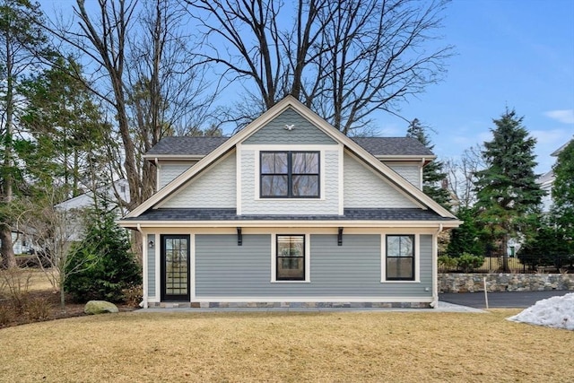 exterior space featuring a yard and a shingled roof