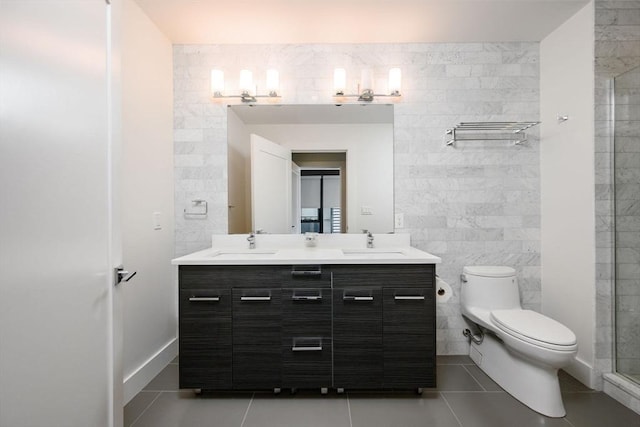 bathroom with tile walls, tile patterned floors, a sink, and toilet