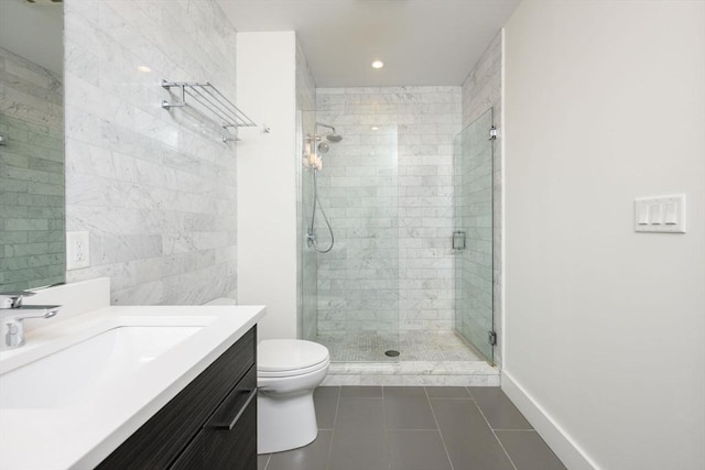 bathroom with tile patterned floors, toilet, vanity, tile walls, and a stall shower