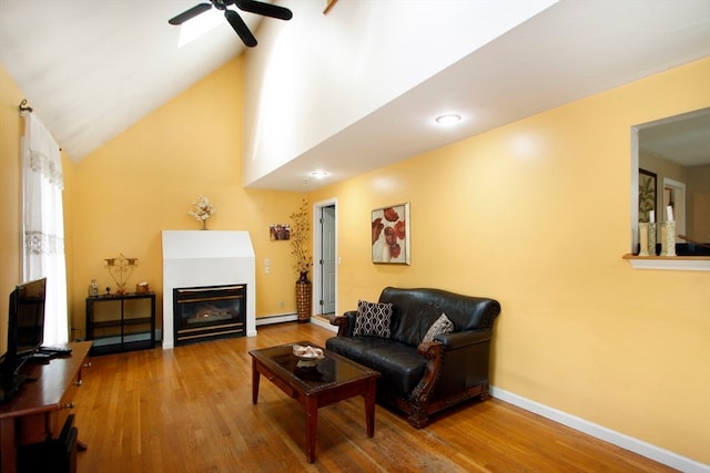 living room featuring hardwood / wood-style flooring, ceiling fan, baseboard heating, and vaulted ceiling