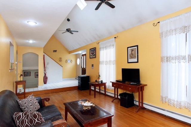 living room with a wealth of natural light, ceiling fan, vaulted ceiling, and hardwood / wood-style flooring