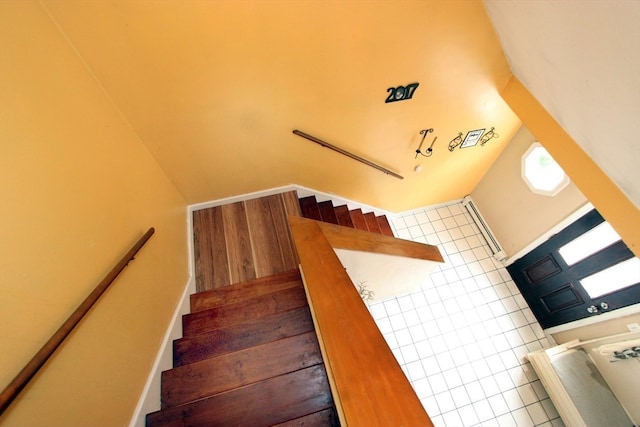 stairs with tile patterned floors and lofted ceiling