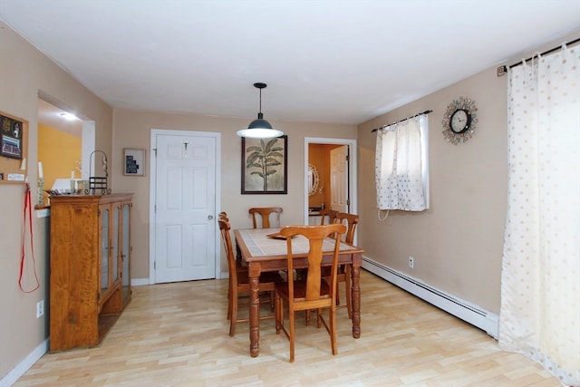 dining room with baseboard heating and light wood-type flooring