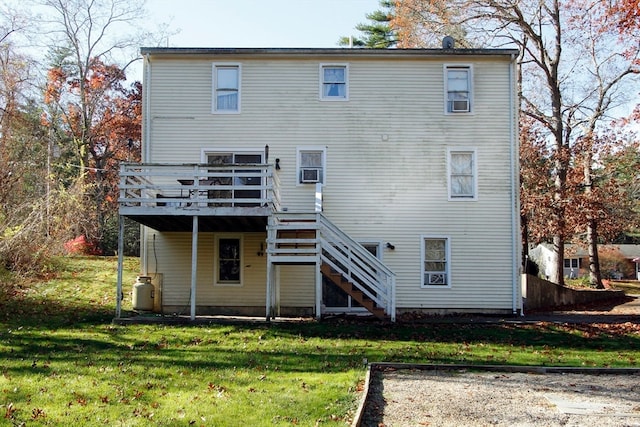 back of house featuring a lawn and a deck