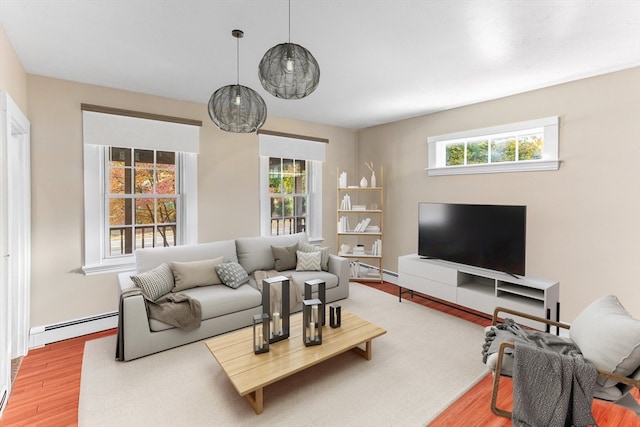 living room featuring a baseboard heating unit and hardwood / wood-style flooring