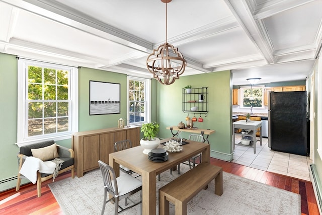 dining area featuring light hardwood / wood-style floors, a healthy amount of sunlight, and beamed ceiling