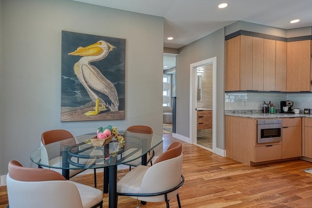 238 Sycamore St Unit 238, Watertown, MA 02472 - kitchen featuring light wood finished floors, tasteful backsplash, light brown cabinets, baseboards, and stainless steel oven