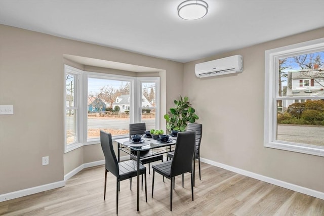 dining room with light hardwood / wood-style flooring and a wall mounted air conditioner