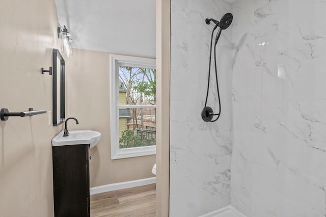 bathroom with hardwood / wood-style floors, vanity, a healthy amount of sunlight, and tiled shower