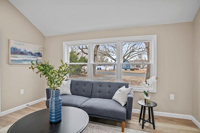 living area featuring a healthy amount of sunlight, light hardwood / wood-style floors, and lofted ceiling