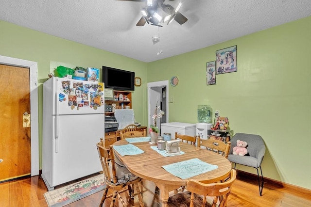 dining room featuring a textured ceiling, ceiling fan, and wood finished floors