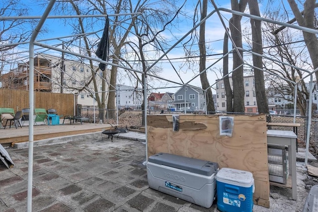 view of patio / terrace featuring fence, a residential view, and an outdoor fire pit