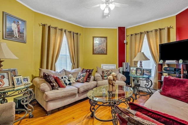 living room featuring a textured ceiling, crown molding, ceiling fan, and wood finished floors