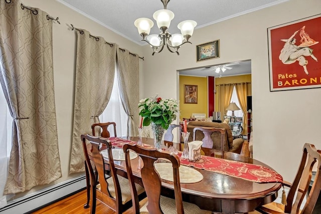 dining area with a baseboard radiator, wood finished floors, crown molding, and ceiling fan with notable chandelier