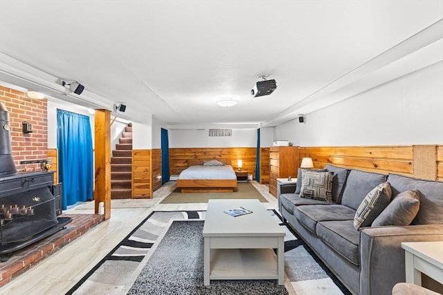 bedroom featuring a wainscoted wall, a wood stove, and visible vents