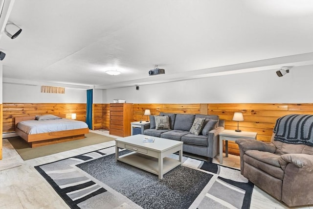 bedroom featuring baseboard heating, wood walls, and wainscoting