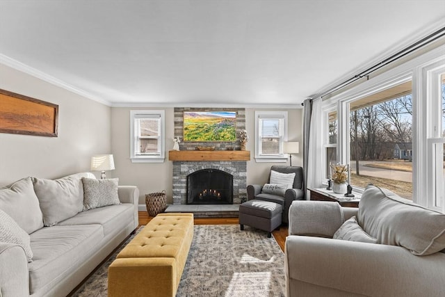 living room with a stone fireplace, wood finished floors, and ornamental molding