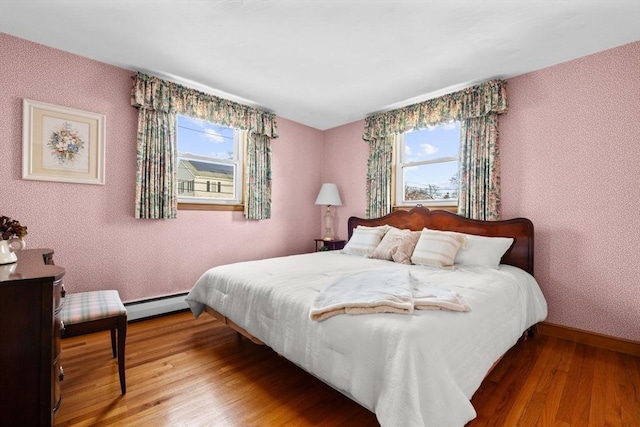 bedroom featuring baseboard heating and hardwood / wood-style floors