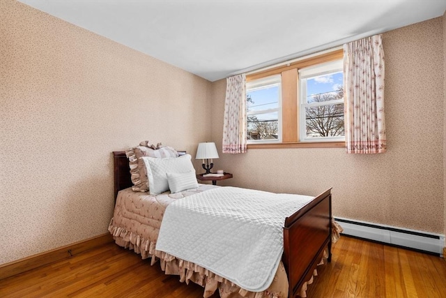 bedroom featuring hardwood / wood-style flooring and a baseboard radiator