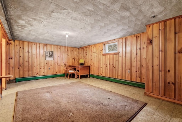 recreation room featuring wood walls and baseboard heating