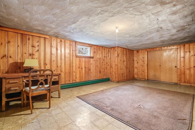 interior space with wood walls and a baseboard heating unit