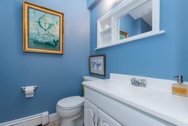 6 Willow St, Wellesley, MA 02481 - half bath featuring a baseboard heating unit, toilet, vanity, and baseboards