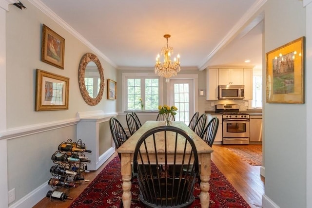 6 Willow St, Wellesley, MA 02481 - dining space featuring a chandelier, ornamental molding, light wood-type flooring, and baseboards