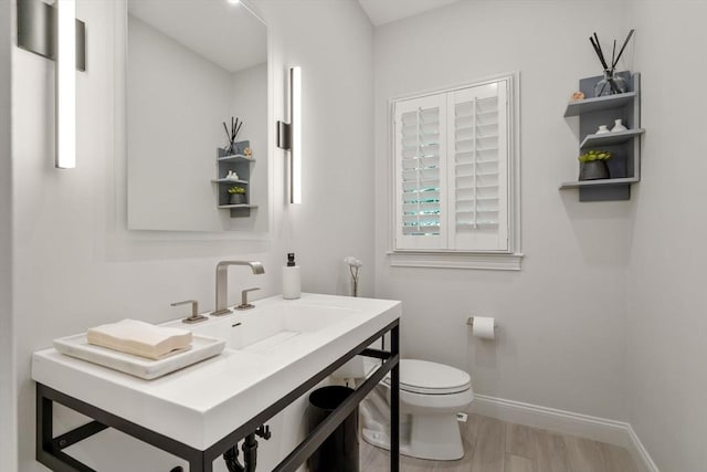 127 Shade St, Lexington, MA 02421 - half bath featuring toilet, baseboards, wood finished floors, and vanity