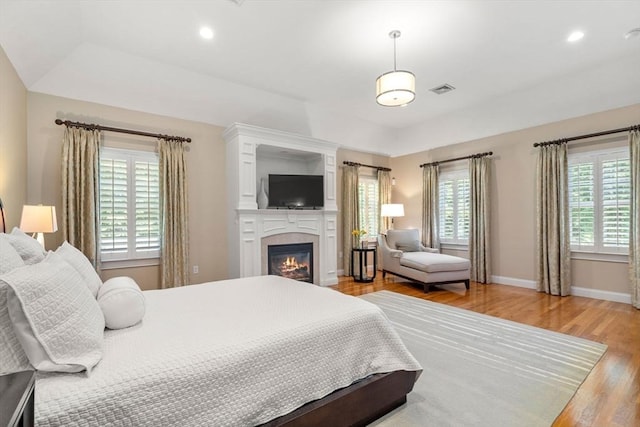 127 Shade St, Lexington, MA 02421 - bedroom with light wood-style flooring, a glass covered fireplace, baseboards, and recessed lighting