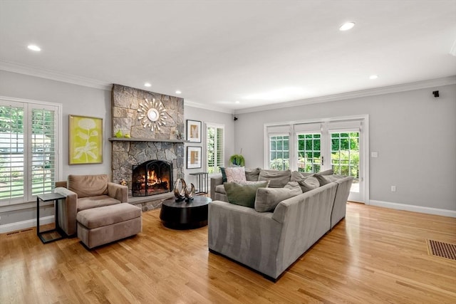 127 Shade St, Lexington, MA 02421 - living room featuring crown molding, light wood-type flooring, baseboards, a stone fireplace, and recessed lighting