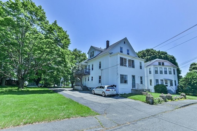18 Emerald Ave, Webster, MA 01570 - view of side of home with a yard, a chimney, and a balcony