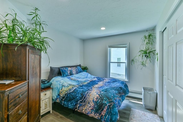 18 Emerald Ave, Webster, MA 01570 - bedroom with light wood-style flooring, a baseboard radiator, recessed lighting, and a textured ceiling