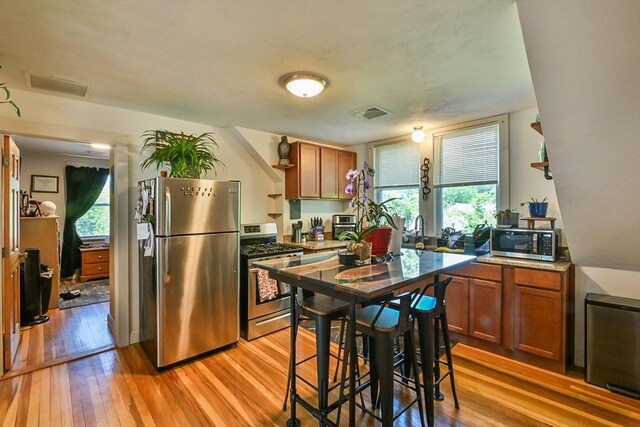 18 Emerald Ave, Webster, MA 01570 - kitchen featuring appliances with stainless steel finishes, light wood finished floors, and brown cabinetry