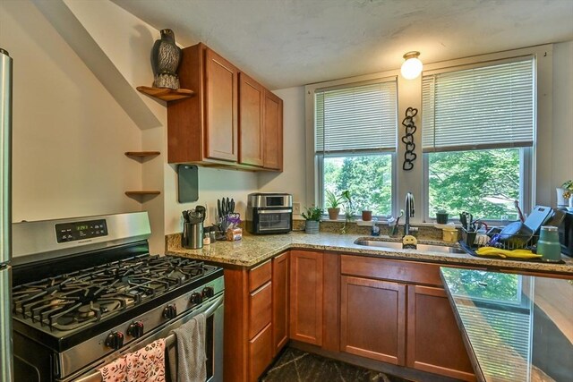 18 Emerald Ave, Webster, MA 01570 - kitchen with stainless steel range with gas cooktop, open shelves, light stone counters, and brown cabinetry