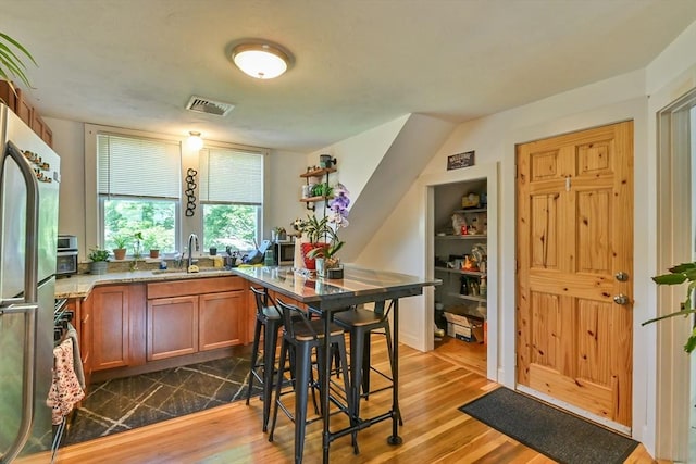 18 Emerald Ave, Webster, MA 01570 - kitchen with freestanding refrigerator, dark wood-type flooring, brown cabinetry, and light stone countertops