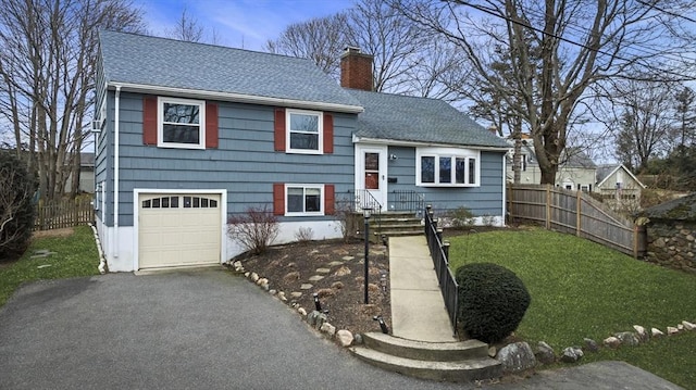 split level home featuring a garage and a front lawn