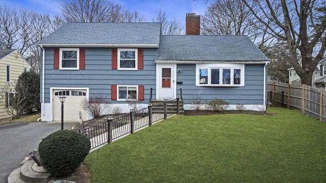 tri-level home featuring a garage and a front yard