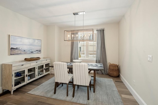 dining area featuring an inviting chandelier and dark wood-type flooring